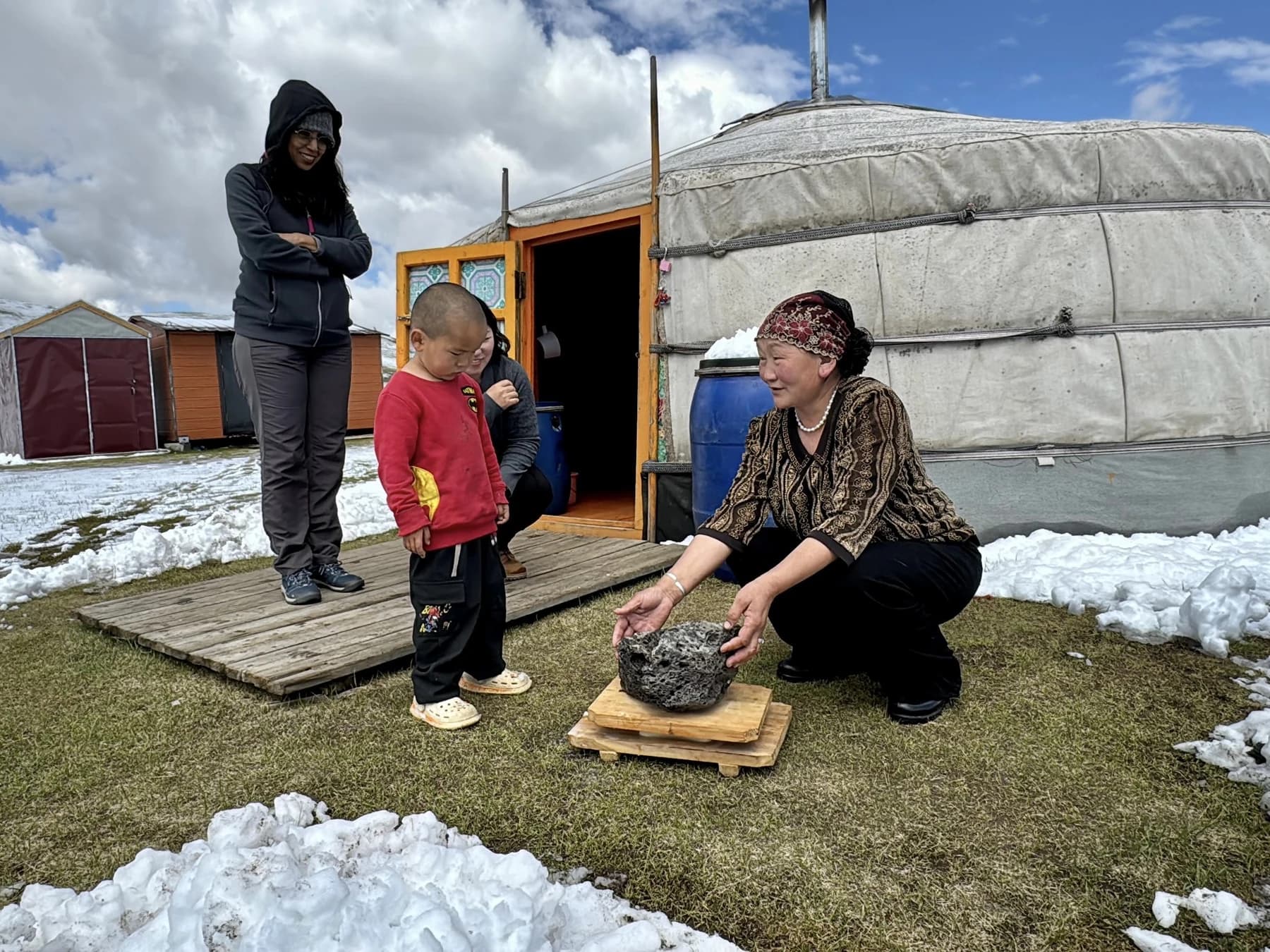 Hosts and visitors outside a ger